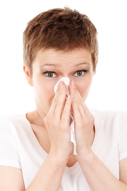 femme qui se mouche dans un mouchoir en papier