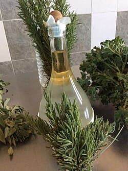 Flacon d'huile essentielle de romarin fraîchement distillée, entouré de brins de romarin
